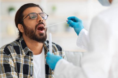 Hintli adam evde koronavirüs testi yaptırıyor.