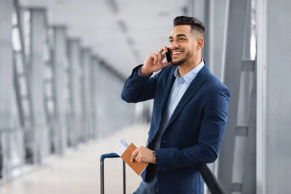 Bonito empresário do Oriente Médio conversando no celular enquanto espera no lounge do aeroporto — Fotografia de Stock