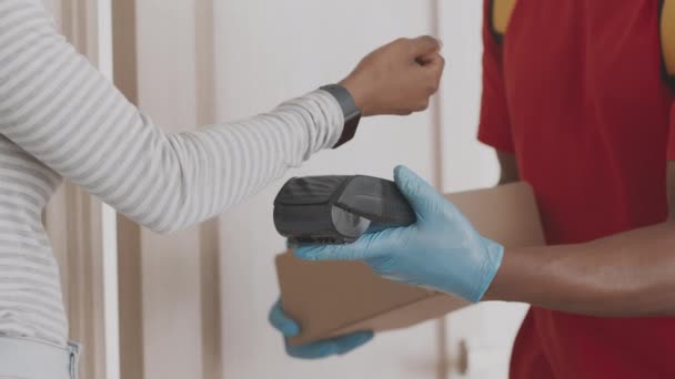 Gros plan de la femme noire payant pour l'ordre avec smartwatch, prenant boîte de courrier dans des gants de protection — Video