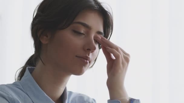 Överarbete och professionell utbrändhet. Närbild porträtt av ung kvinna manager känsla migrän, gnida hennes näsbro — Stockvideo