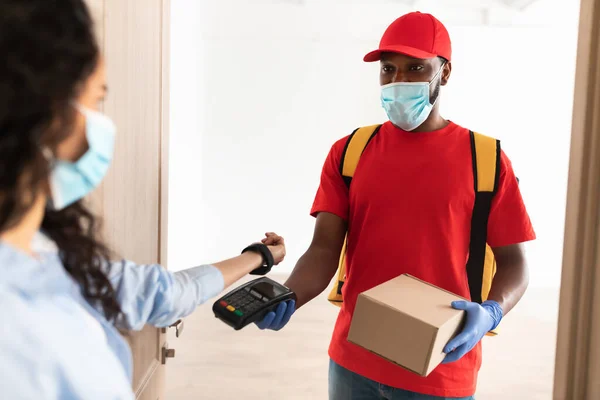 Black man holding POS machine lady paying with smart watch — Stock Photo, Image