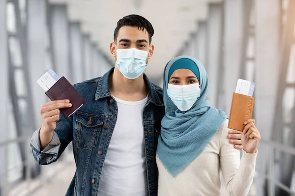 Retrato de pareja musulmana con máscaras con pasaportes y entradas en el aeropuerto —  Fotos de Stock