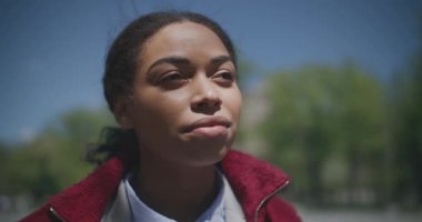 Güzel bir yaz günü. Genç, barışçıl, Afro-Amerikan bir kadın parkta duruyor ve nefes alıyor.