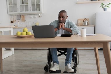 Düşünceli yetişkin işadamı e-posta yolluyor, video dersi izliyor ve evde vergilerle çalışıyor.