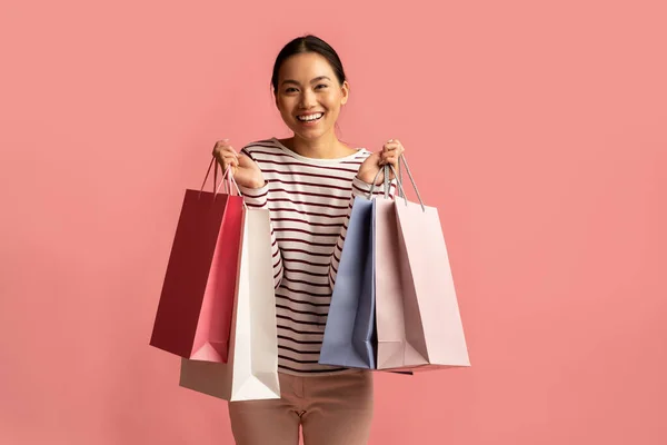 Glada unga asiatiska dam Posing med massor av ljusa papper shoppingväskor — Stockfoto