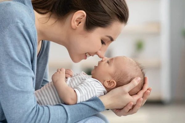 Dal naso al naso. Giovane madre giocare con suo neonato a casa — Foto Stock