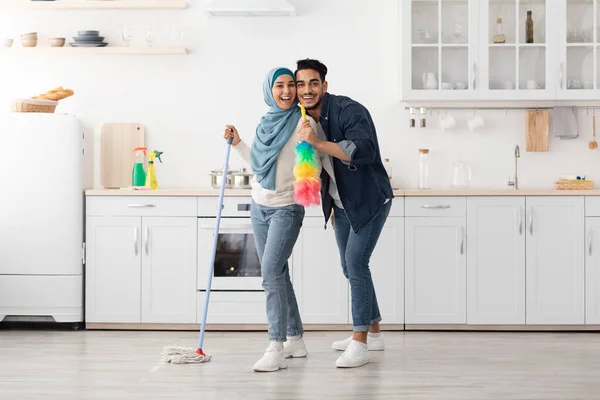 Αγαπώντας muslim ζευγάρι καθαρισμού πάτωμα και τη διασκέδαση στην κουζίνα — Φωτογραφία Αρχείου