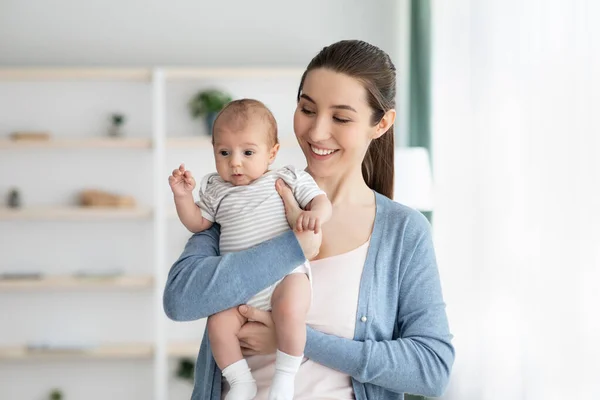 Feliz Concepto de Maternidad. Mujer joven sonriente con un niño recién nacido adorable en las manos —  Fotos de Stock