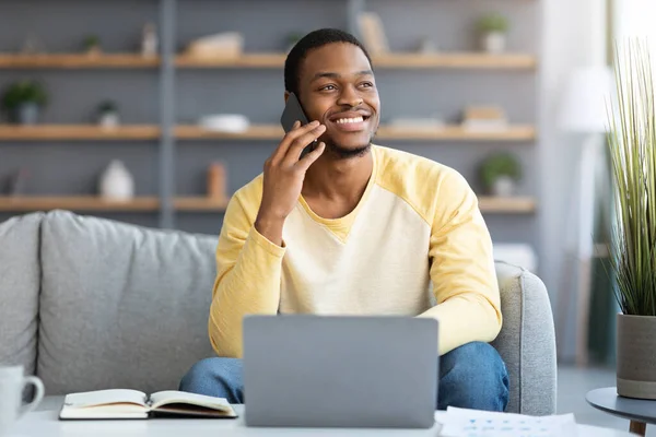 Joyful negro chico freelancer teniendo conversación telefónica — Foto de Stock