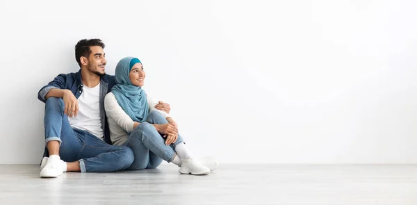 Щаслива жінка в хіджабі сидить на підлозі зі своїм чоловіком — стокове фото