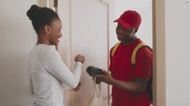 Yemek servisi. Siyahi kurye, Afrikalı Amerikan kadınlarına market siparişi getiriyor. Kadın da akıllı hatunla ödeme yapıyor.