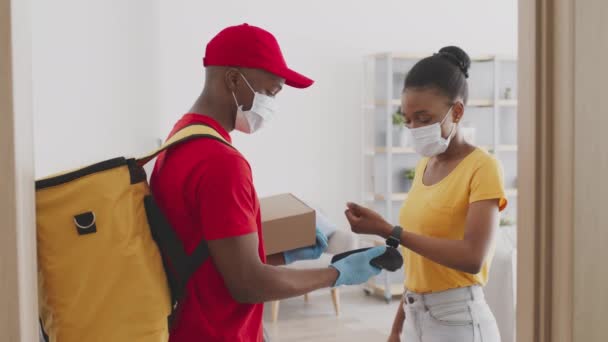 Online nakupování a doprava. Mladý africký americký dáma platit za balíček s smartwatch a dostat box — Stock video