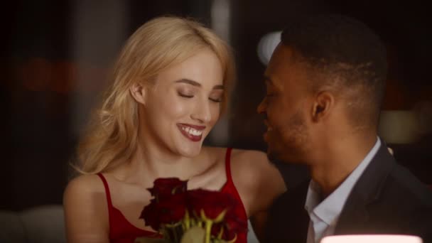 Novio dando rosas a la novia durante la cita romántica en el restaurante — Vídeos de Stock