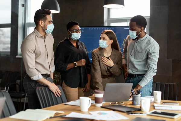 Colegas con máscaras que se reúnen en la sala de juntas, hablando — Foto de Stock