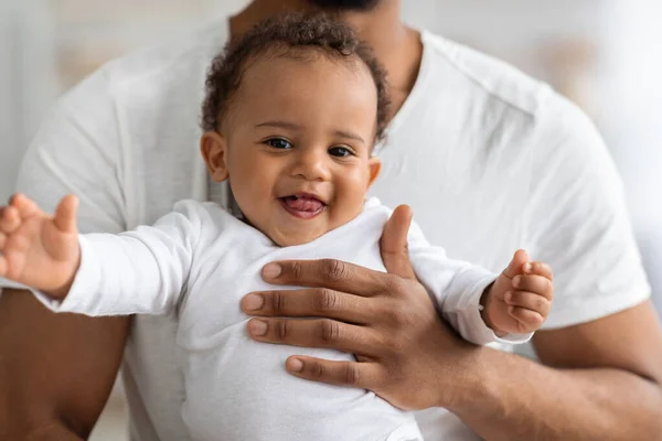 Primer plano retrato de adorable negro bebé niño relajarse en las manos de los padres — Foto de Stock