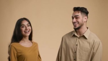 Gülümseyen ve onaylayan Arap çift, bej arka plan