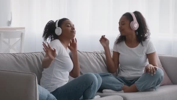 Koníček obyčejných sester. Mladá žena a dospívající dívka těší velký zvuk moderní hudby v bezdrátových sluchátkách — Stock video