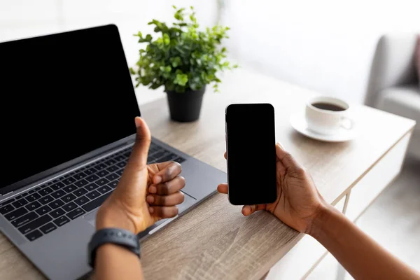 Mujer negra irreconocible con teléfono celular y portátil recomendando nueva aplicación o sitio web de compras móviles, maqueta — Foto de Stock