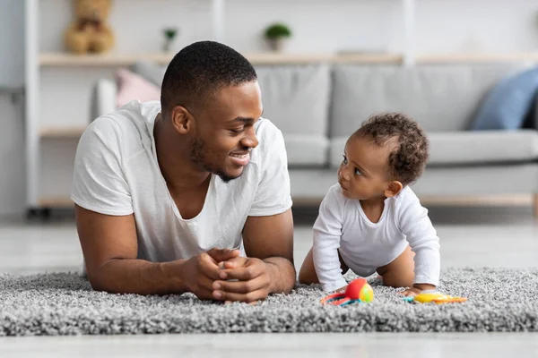 Młody czarny tata i jego urocze dziecko relaks razem w domu — Zdjęcie stockowe