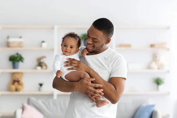 Jonge zwarte vader houden zijn schattige pasgeboren baby, teder omarmen zuigeling kind — Stockfoto