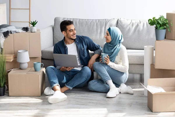Возбужденные Арабы планируют новый ремонт квартиры, используя ноутбук — стоковое фото