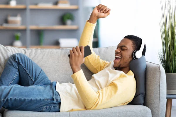 Emotionaler afrikanisch-amerikanischer Mann hört Musik auf Handy — Stockfoto