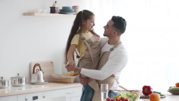 Středovýchodní tatínek a dceruška tančí baví v kuchyni — Stock video