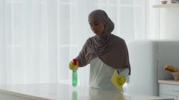 Мусульманская домохозяйка в хиджабе Чистка кухонного стола дома — стоковое видео