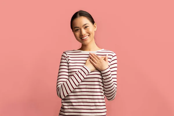 Dankbaarheid concept. Dankbare jonge Aziatische vrouw houden beide handpalmen op de borst — Stockfoto