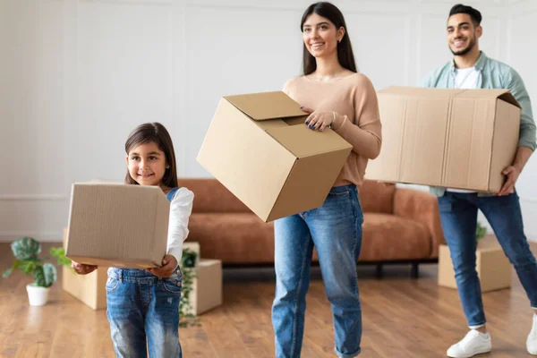 Happy young family of three carling boxes in new flat — Stok Foto