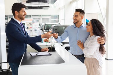 Heyecanlı orta doğulu çift büyük bir galeriden araba alıyor.