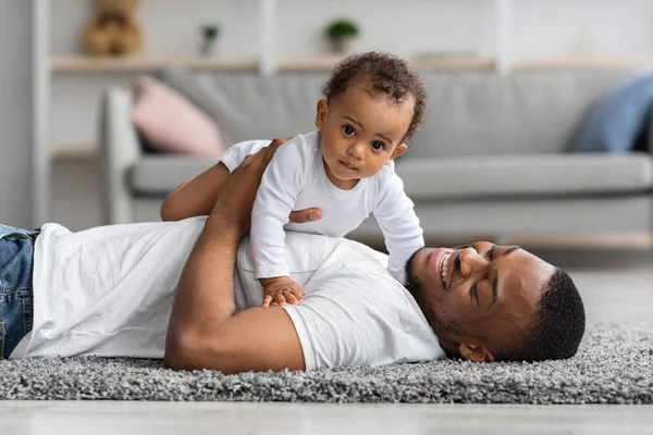 彼らは自宅でリラックスしながら、父親の胸に横たわっている愛らしい赤ちゃんの男の子 — ストック写真