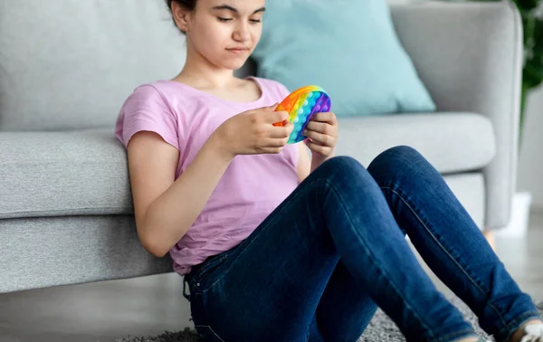 Gesneden weergave van cool tienermeisje spelen met POP IT speelgoed thuis, selectieve focus — Stockfoto