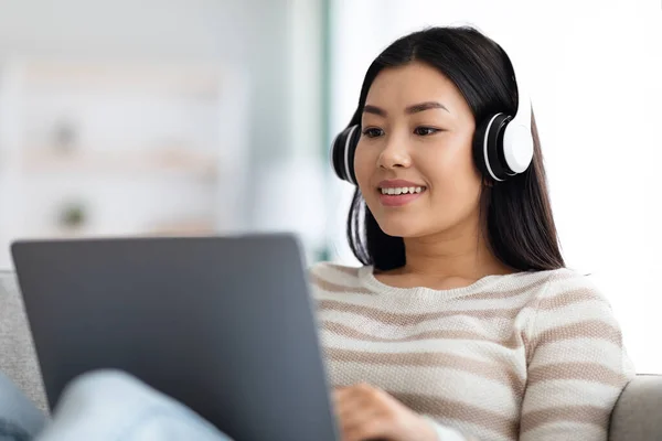 Onlineexamen. Ung asiatisk kvinna i headset studie med laptop hemma, — Stockfoto