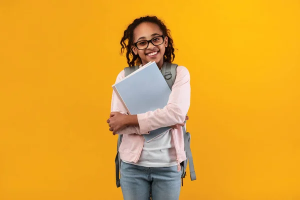 Allegro giovane ragazza nera in possesso di libri di testo guardando la fotocamera — Foto Stock