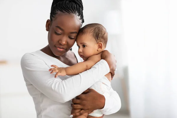 Afro-Amerikan dadı tatlı bebeğine evde sarılıyor. — Stok fotoğraf