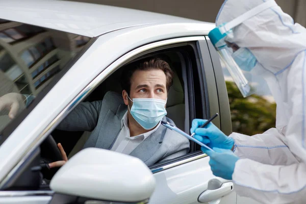Checks passengers and driver for virus, man in biological suit writes data on tablet, COVID-19 quarantine — Stock Photo, Image