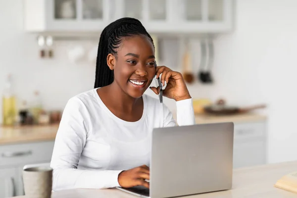 Sorrindo mulher negra trabalhando e falando no telefone em casa — Fotografia de Stock