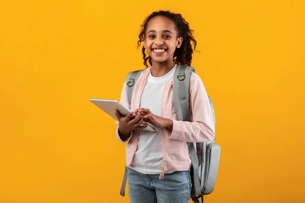 Black girl standing with tablet at yellow studio — Stock Photo, Image