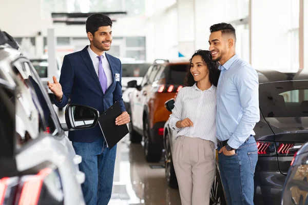 Beautiful middle-eastern couple buying car in brand new showroom — Stock Photo, Image