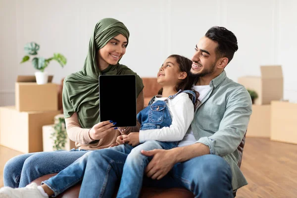 Счастливая мусульманская семья делает ремонт женщина показывает планшет — стоковое фото