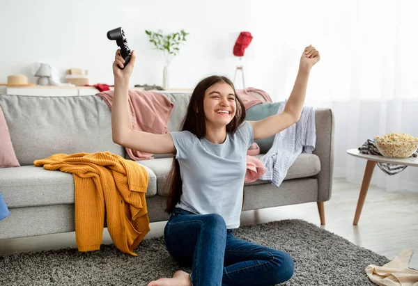 Feliz indio adolescente chica ganar videojuego en playstation, divertirse, celebrando la victoria en el interior — Foto de Stock