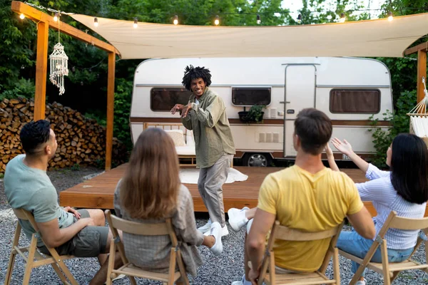 Jeunes amis multiraciaux jouer devinez qui jeu, rire, s'amuser ensemble près du camping-car à l'extérieur — Photo