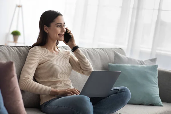 与客户在手机上交谈的女性，在家用笔记本电脑远程办公，新常态 — 图库照片
