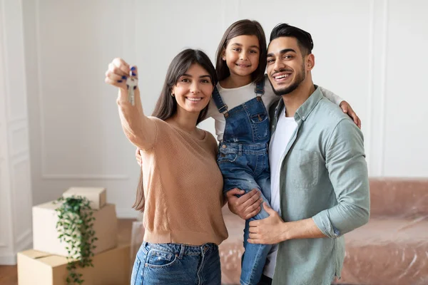 Счастливая молодая семья показывает ключи от квартиры — стоковое фото