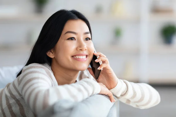 Retrato de feliz joven asiática mujer hablando en el teléfono móvil en casa — Foto de Stock
