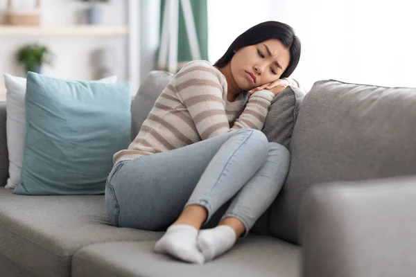 Концепція депресії. Портрет сумної азіатки сидить на дивані вдома — стокове фото