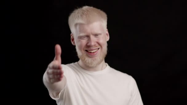 Happy Albino Man Offering Hand To Camera Over Black Background — Vídeo de Stock