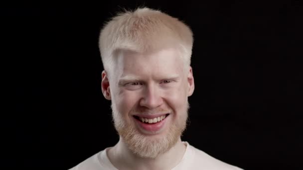 Headshot Of Beautiful Albino Mies hymyilevä poseeraa yli musta tausta — kuvapankkivideo