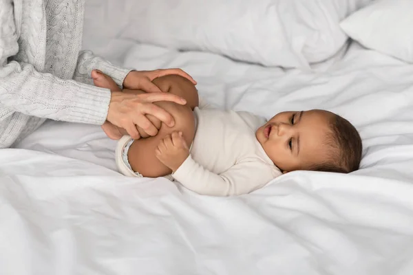 Oigenkännlig kvinna som gör gymnastik med liten svart baby — Stockfoto